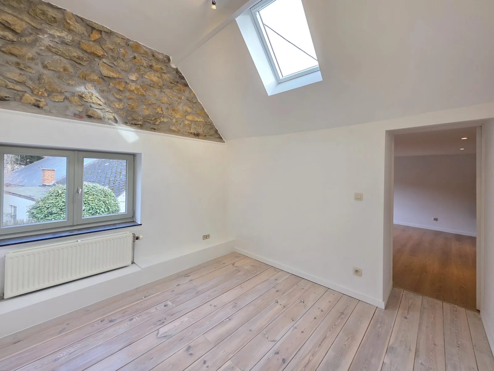 Chambre sous rampant avec velux et mur en pierre